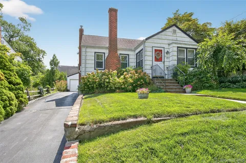 a front view of a house with a yard and potted plants