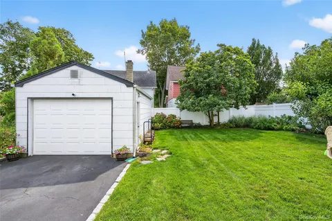a front view of a house with a yard and trees