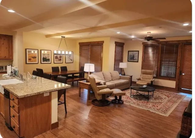 a kitchen with stainless steel appliances granite countertop wooden cabinets a stove top oven a granite counter space and a sink