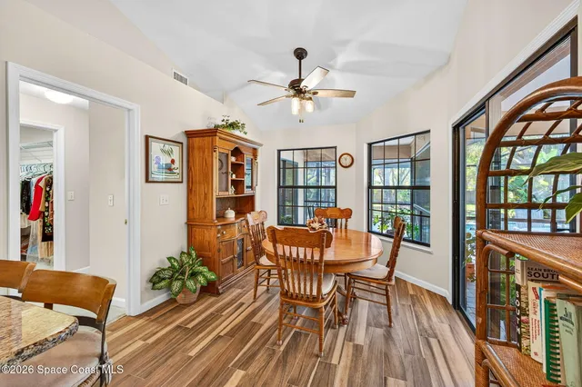 a dining room with furniture a book and wooden floor