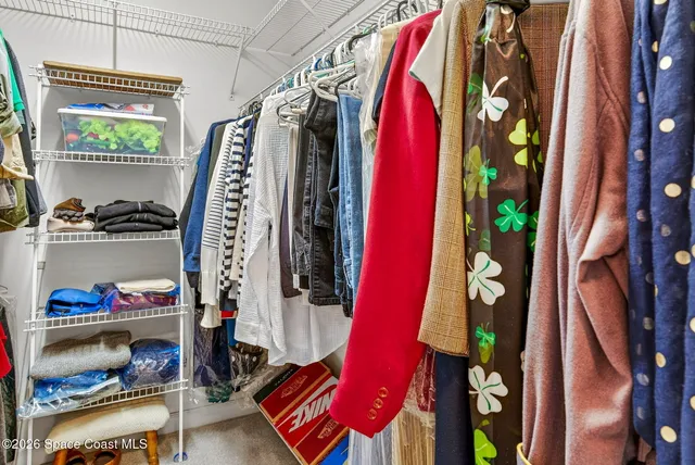 a view of walk in closet with clothes and shoes