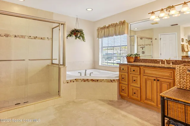 a spacious bathroom with a granite countertop sink a mirror and a bathtub