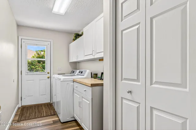 a kitchen with white cabinets and window