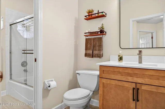 a bathroom with a toilet sink vanity and mirror