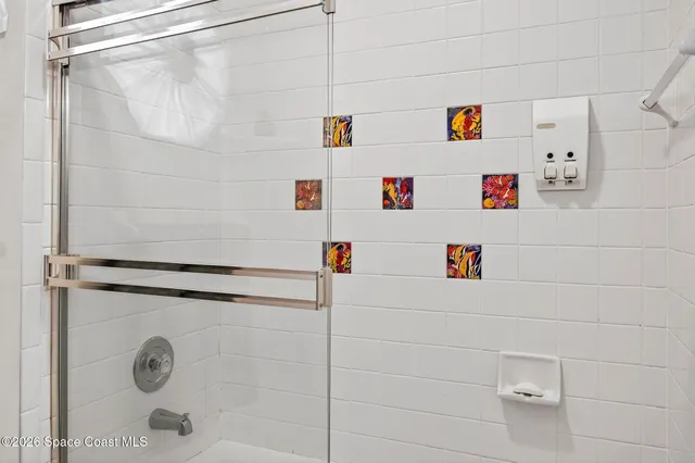 a bathroom with a refrigerator and a shower