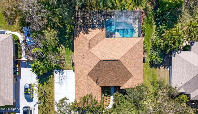 an aerial view of a house with garden space and trees