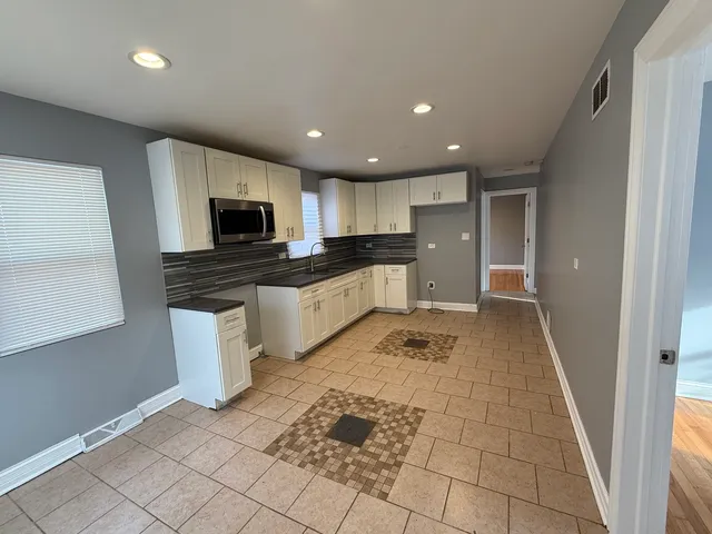 a kitchen with stainless steel appliances granite countertop a refrigerator and a stove top oven