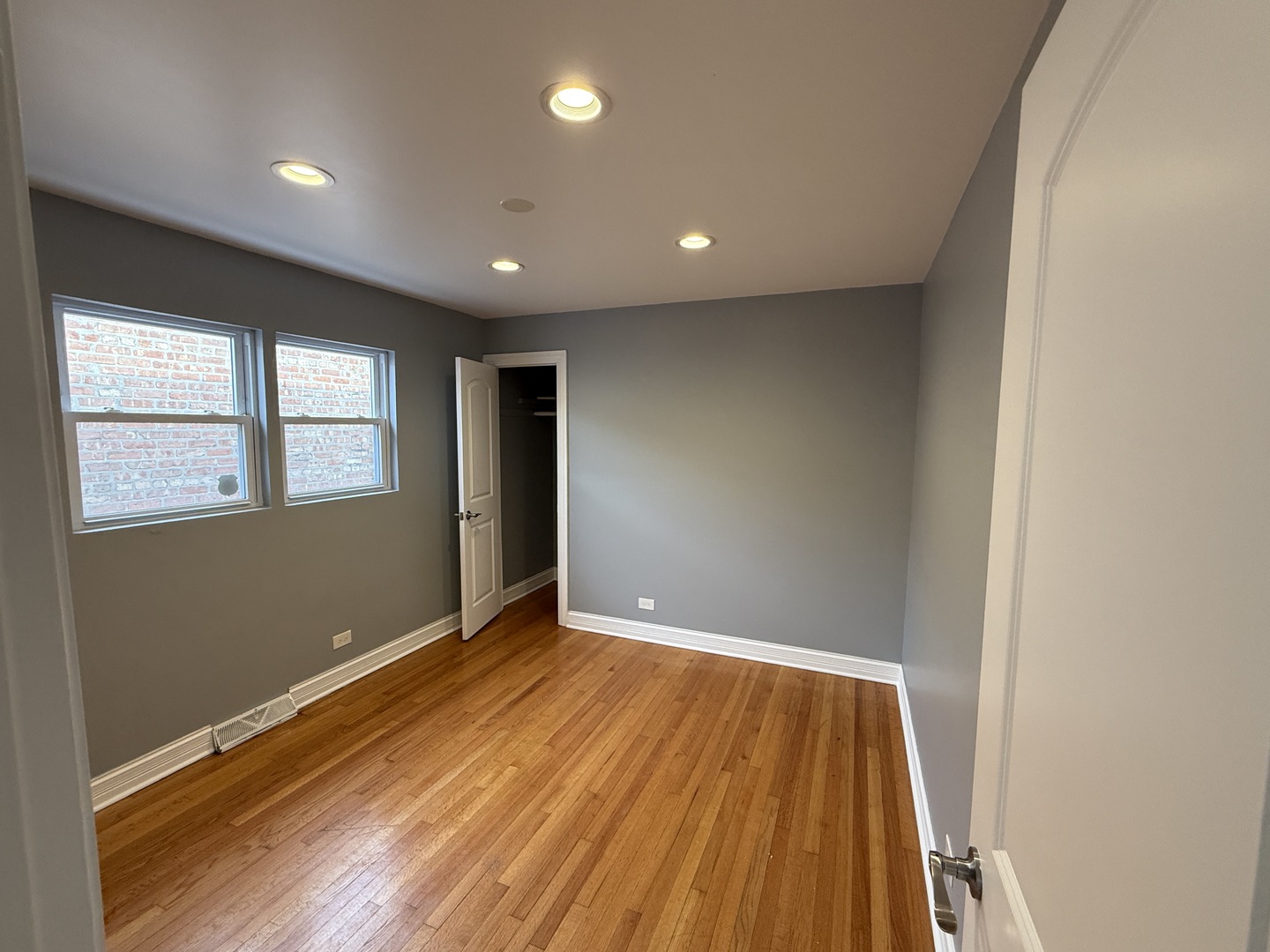 9710 South Chappel Avenue Chicago, IL 60617 - Photo 8 of 11 an empty room with wooden floor and windows