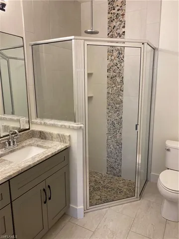 a bathroom with a granite countertop sink toilet and shower