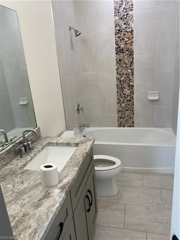 5314 30th Street Southwest Lehigh Acres, FL 33973 - Photo 15 of 19 a bathroom with a granite countertop sink toilet and shower