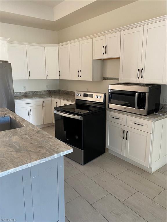 5314 30th Street Southwest Lehigh Acres, FL 33973 - Photo 5 of 19 a kitchen with cabinets appliances and a sink