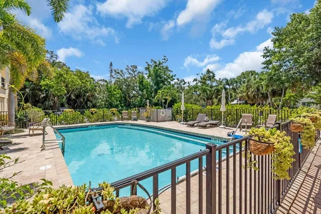 a living room with furniture kitchen view and a wooden floor