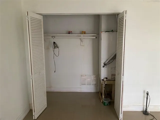 an empty room with wooden door and mirror