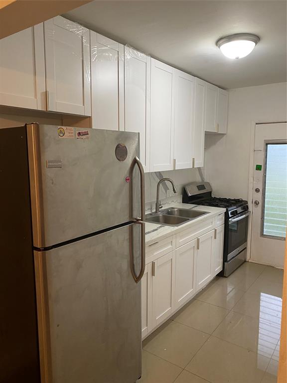 51 Northeast 204th Street, Unit 2 Miami, FL 33179 - Photo 4 of 18 a kitchen with stainless steel appliances granite countertop a refrigerator a sink and white cabinets