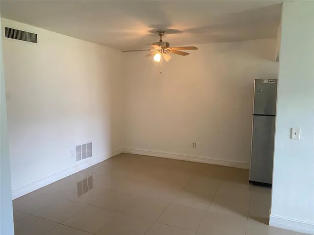 an empty room with a fan and a fan