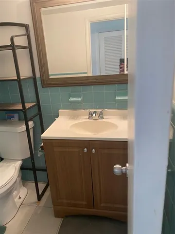a bathroom with a sink a toilet and a mirror