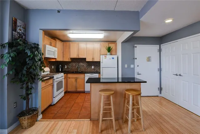 a living room with furniture a large window with kitchen view