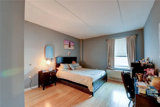 a bedroom with a bed and wooden floor