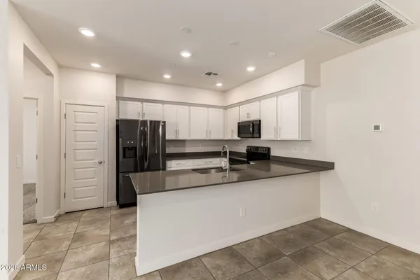 a large kitchen with stainless steel appliances a refrigerator and a stove