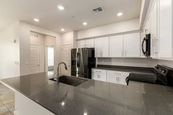 a kitchen with stainless steel appliances granite countertop a sink a stove and a refrigerator