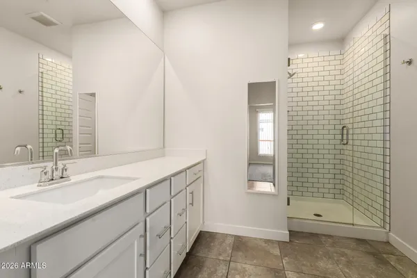 a bathroom with a shower sink and mirror