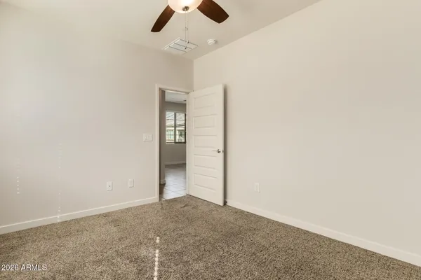 an empty room with chandelier fan