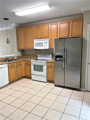 a kitchen with a refrigerator sink and cabinets