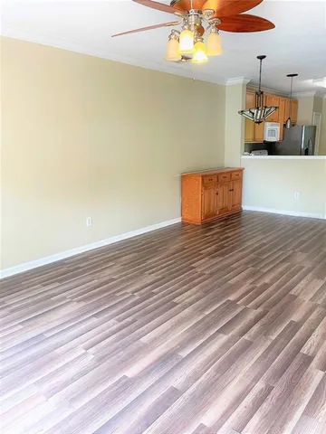 wooden floor in an empty room with a chandelier fan