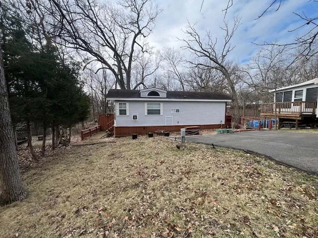 a front view of a house with a yard covered with snow and trees