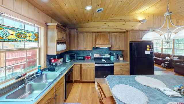 a kitchen with stainless steel appliances granite countertop a sink a stove and a refrigerator