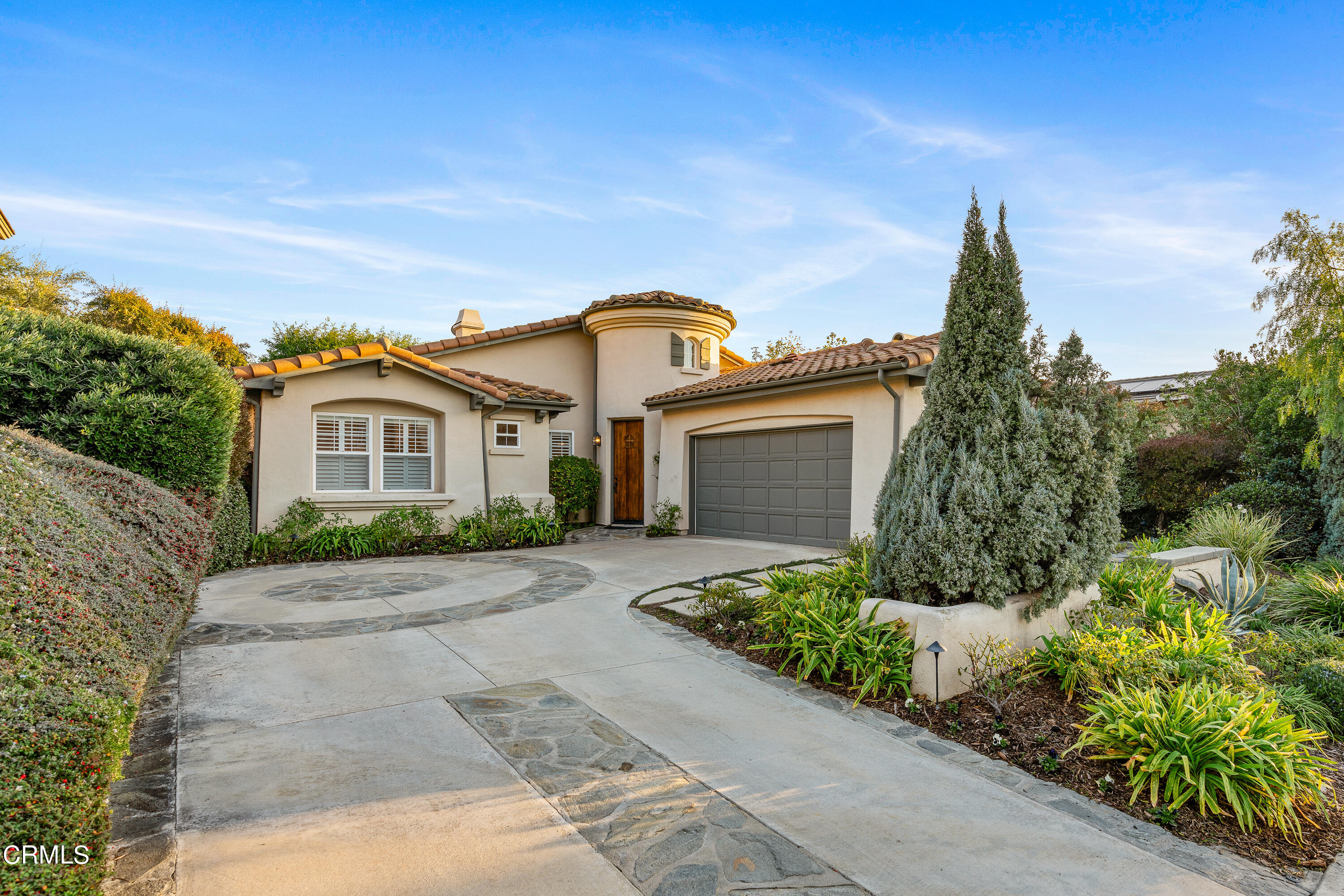 a front view of a house with a yard and potted plants