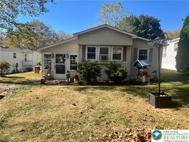 a front view of house with yard outdoor seating and barbeque oven