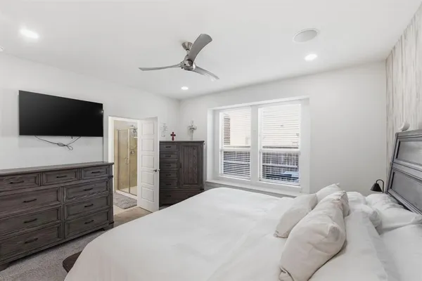 a bedroom with a large bed and a flat screen tv