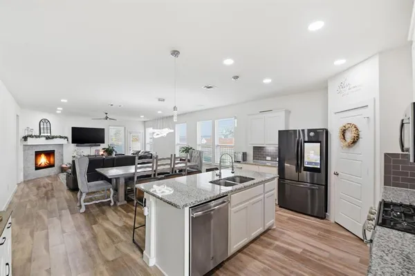 a kitchen that has a lot of cabinets a sink and appliances
