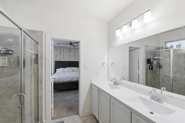 a en suite bathroom with a shower sink and mirror