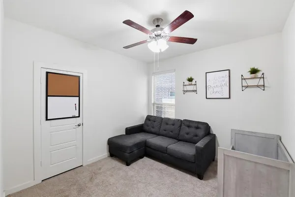 a living room with furniture and a ceiling fan
