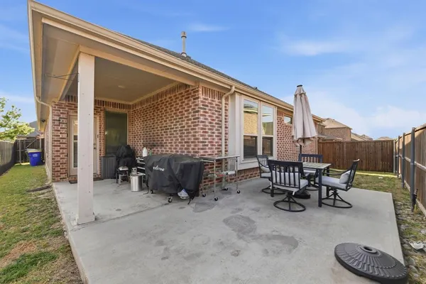 a view of a patio with dining table and chairs