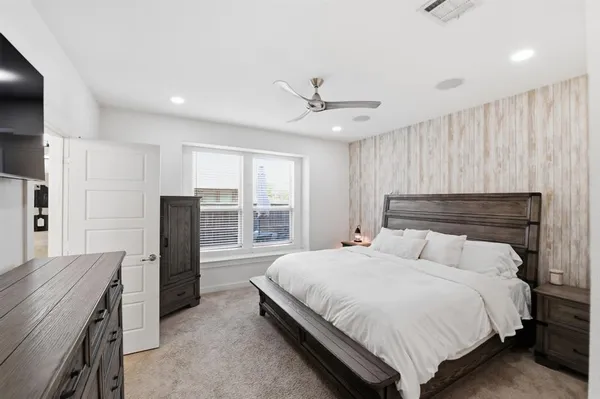 a bedroom with a bed and a refrigerator