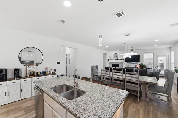 a kitchen with a stove a sink and dishwasher with wooden floor