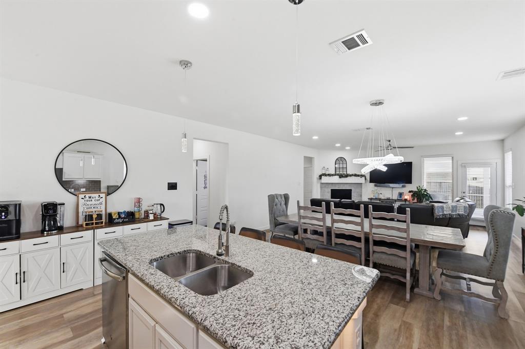 7645 Spring Drive Watauga, TX 76148 - Photo 10 of 28 a kitchen with a stove a sink and dishwasher with wooden floor