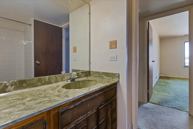 a bathroom with a granite countertop sink and a mirror