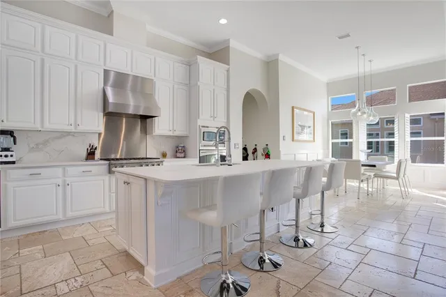 a kitchen with cabinets and chairs