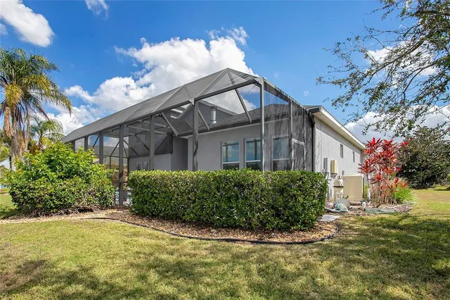 a view of a white house with a big yard and large trees