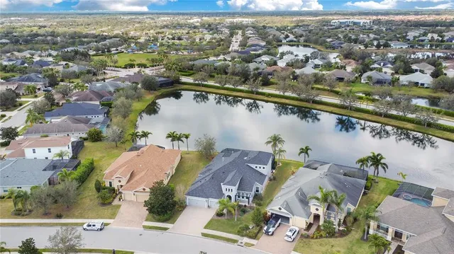 an aerial view of residential houses with outdoor space and lake view