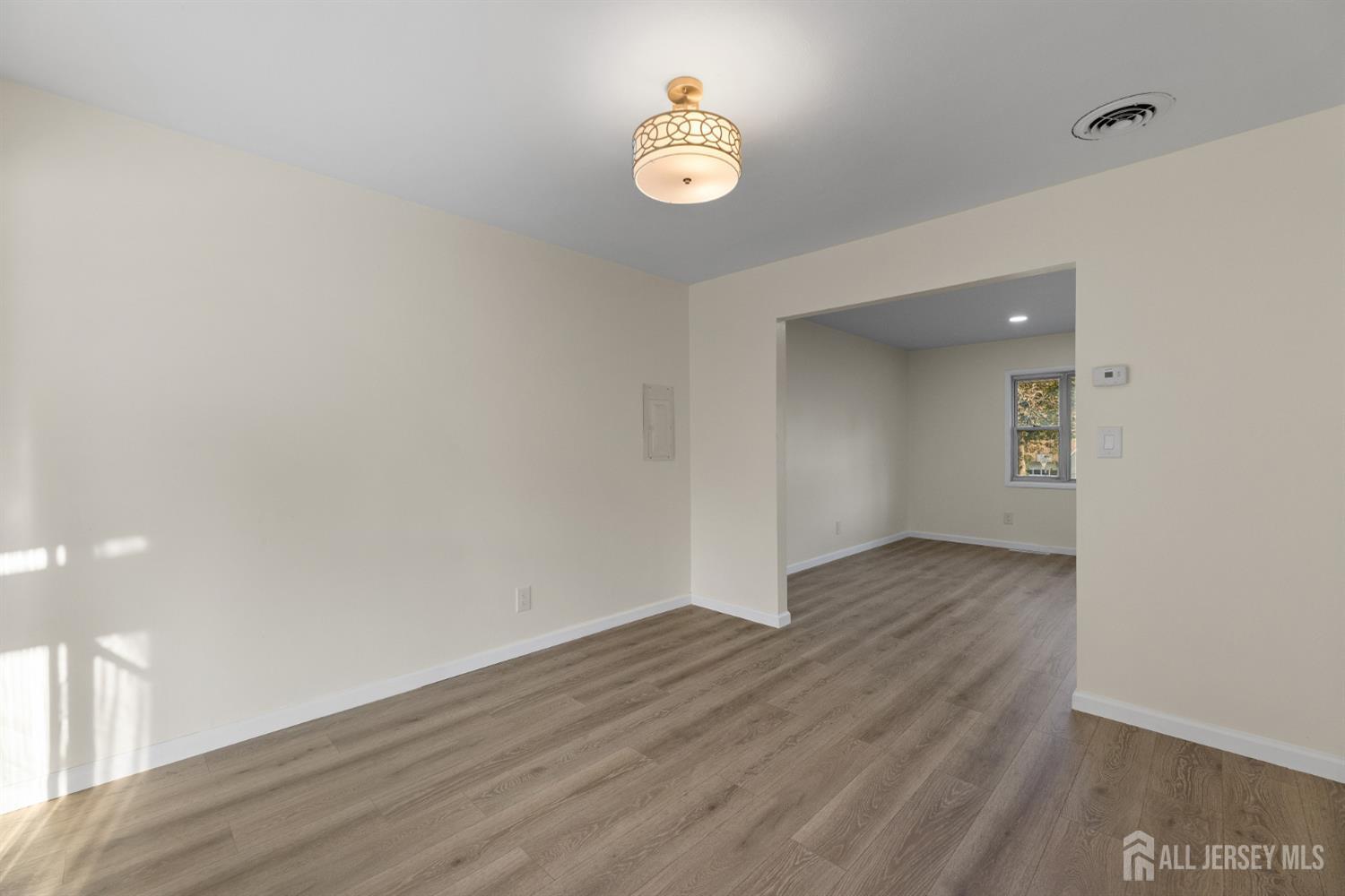 41 Raleigh Road Kendall Park, NJ 08824 - Photo 11 of 40 a view of an empty room with wooden floor and a window