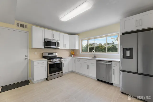 a kitchen with cabinets stainless steel appliances and window