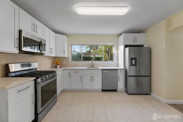 a kitchen with granite countertop a refrigerator stove and microwave
