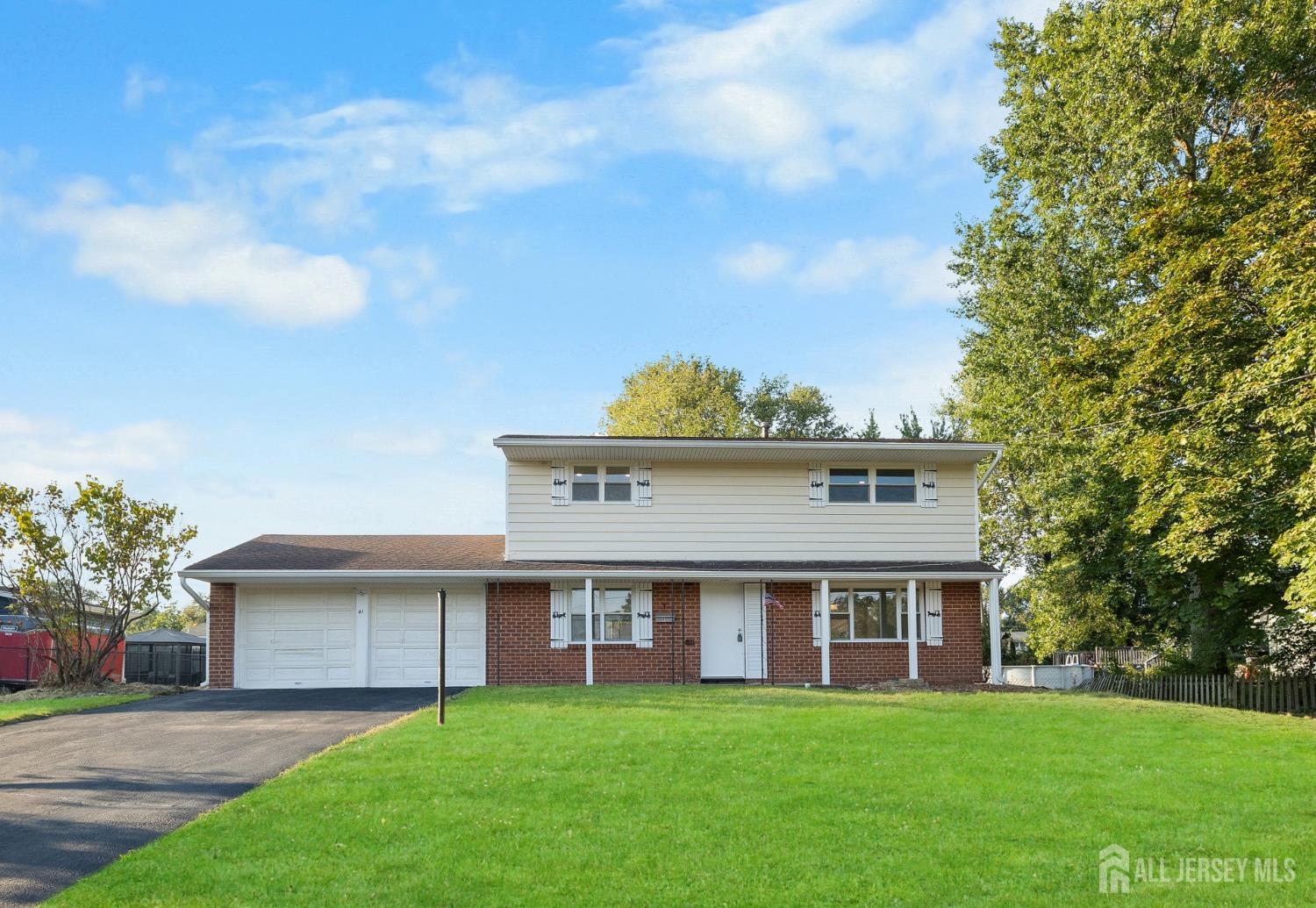41 Raleigh Road Kendall Park, NJ 08824 - Photo 2 of 40 a view of a white house with a big yard and potted plants and trees