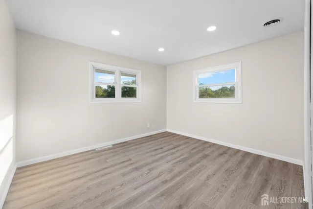 an empty room with wooden floor and window