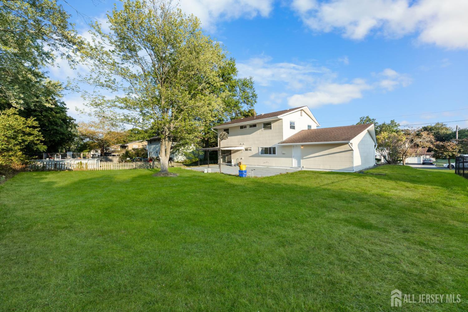 41 Raleigh Road Kendall Park, NJ 08824 - Photo 31 of 40 a view of a white house with a big yard and large trees